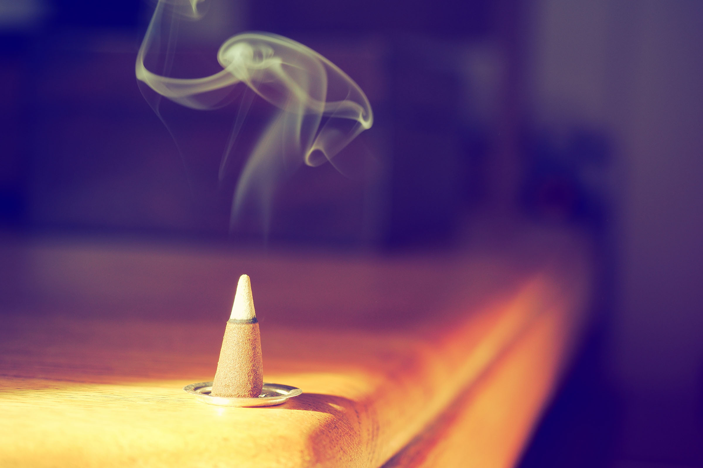 Incense cone on a wooden table in the sunshine shot with a vinta